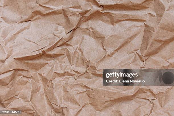 crumpled brown paper texture background showcasing natural fibers and organic patterns, ideal for creative design and artistic projects - arrugado fotografías e imágenes de stock