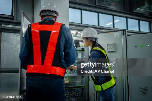 Industrial technicians working electrical control cabinet panel is well-organized for manufacturing, HVAC, or power distribution and organized technical environment. Industrial technicians working electrical control cabinet panel is well-organized for manufacturing, HVAC, or power distribution and organized technical environment.