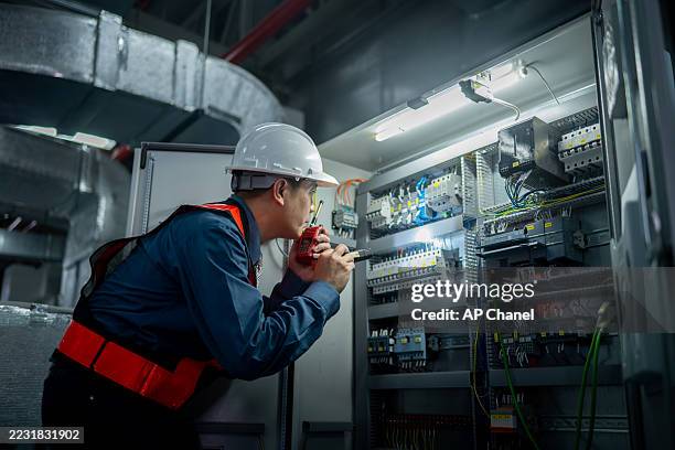 les techniciens industriels travaillant le panneau de l’armoire de commande électrique sont bien organisés pour la fabrication, le cvc ou la distribution d’énergie et l’environnement technique organisé. - technicien photos et images de collection