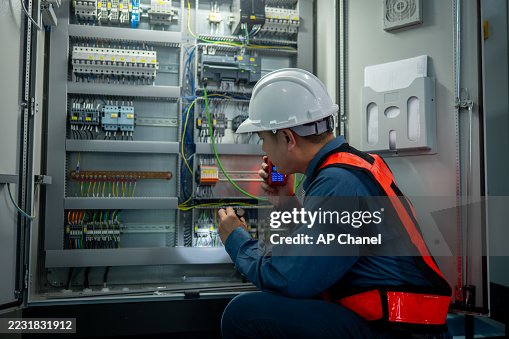 Industrial technicians working electrical control cabinet panel is well-organized for manufacturing, HVAC, or power distribution and organized technical environment. Industrial technicians working electrical control cabinet panel is well-organized for manufacturing, HVAC, or power distribution and organized technical environment.