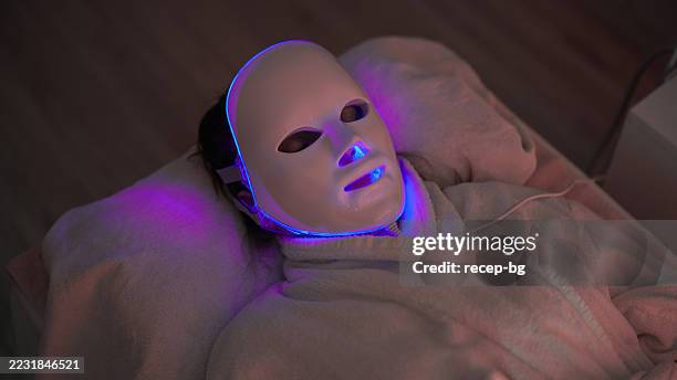 mujer que recibe terapia con máscara de luz led en esteticista - led fotografías e imágenes de stock