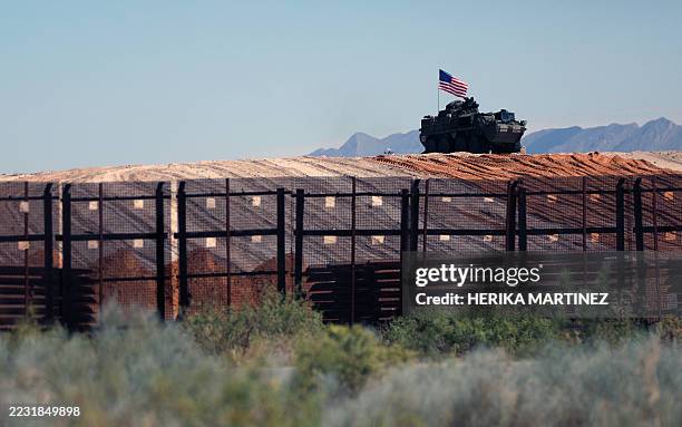 An eight-wheeled military vehicle patrols near the border wall which is being painted black after an order by US President Donald Trump, according to...