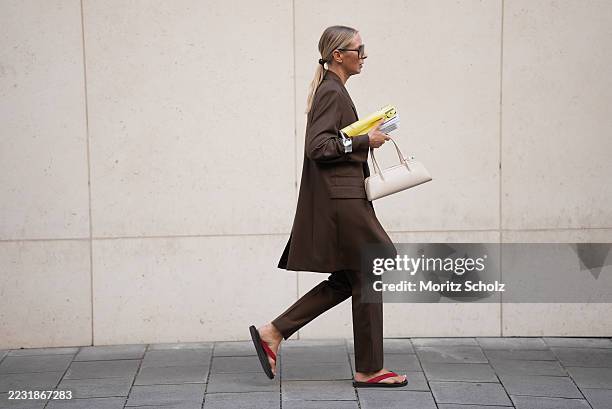 Mirja Klein is seen wearing a tailored chocolate brown oversized blazer with structured shoulders and matching chocolate brown straight-leg trousers...