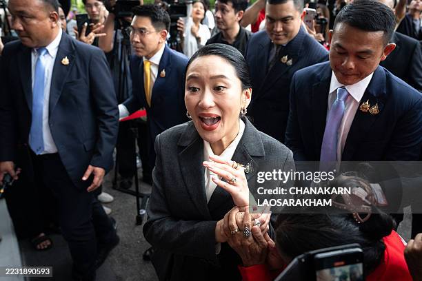 Thailand's sacked prime minister Paetongtarn Shinawatra greets supporters as she arrives at the Pheu Thai Party headquarters after her dismissal by...