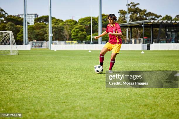 determined female athlete learning to dribble ball - ejercicio de entrenamiento deportivo fotografías e imágenes de stock