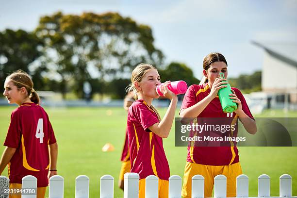 female athletes drinking water while taking break - energydrink stock-fotos und bilder