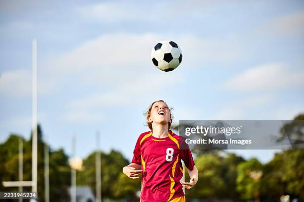 female player practicing soccer skills - faire une tête photos et images de collection