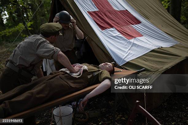 Historical re-enactors portraying the British 49th Infantry Division in World War II simulate a medical emergency in their encampment at The Victory...