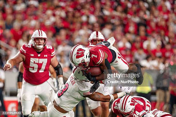 Wisconsin Badgers running back Dilin Jones attempts to jump over Miami RedHawks linebacker Malcolm McCain at Camp Randall in Madison, Wisconsin, on...