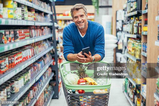 handsome man shopping in supermarket - buy online pick up in store stock pictures, royalty-free photos & images