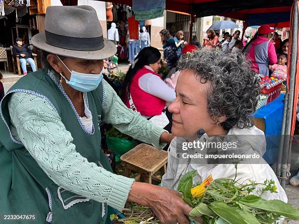 street vendor selling medicinal herbs to a tourist in cuenca - traditional native american medicine stock pictures, royalty-free photos & images