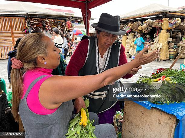 indigenous vendors selling herbs at a traditional market in cuenca, ecuador - traditional native american medicine stock pictures, royalty-free photos & images