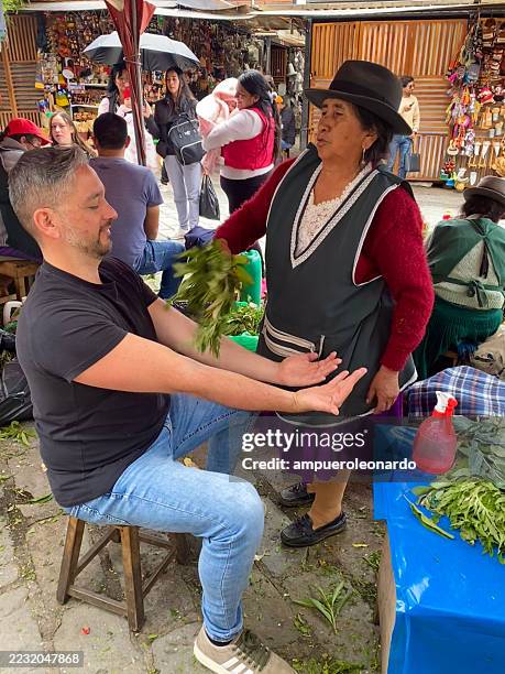indigenous woman performing cleansing ritual with herbs in cuenca, ecuador - traditional native american medicine stock pictures, royalty-free photos & images