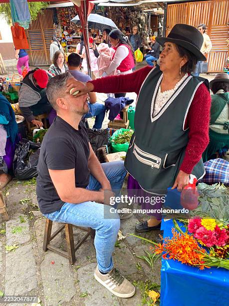 vendor using egg for cleansing ritual on tourist in cuenca, ecuador - traditional native american medicine stock pictures, royalty-free photos & images