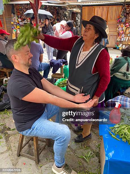 indigenous woman performing cleansing ritual with herbs in cuenca, ecuador - traditional native american medicine stock pictures, royalty-free photos & images