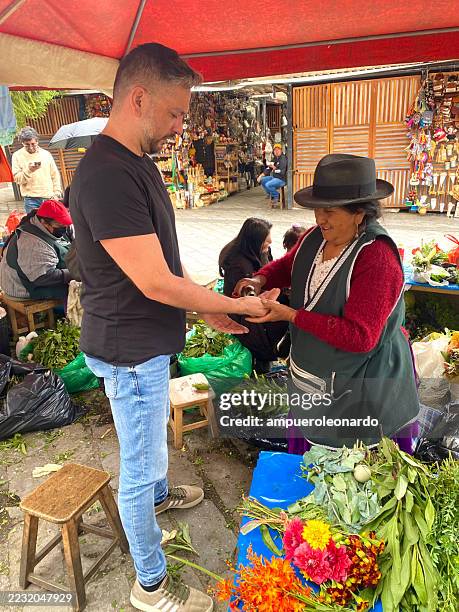indigenous woman performing cleansing ritual with herbs in cuenca, ecuador - traditional native american medicine stock pictures, royalty-free photos & images
