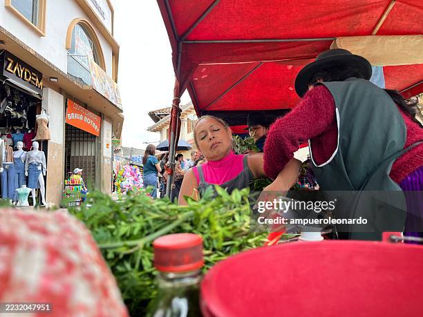 indigenous vendors selling herbs at a traditional market in cuenca, ecuador - traditional native american medicine stock pictures, royalty-free photos & images