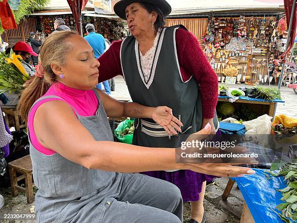 ecuadorian market vendor using alternative medicine on a customer in cuenca - traditional native american medicine stock pictures, royalty-free photos & images