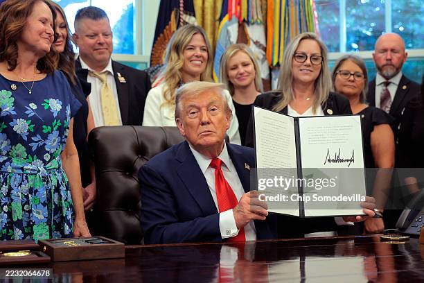 President Donald Trump signs a proclamation on the fourth anniversary of the "Abbey Gate" terrorist attack, as he is joined by family members of...