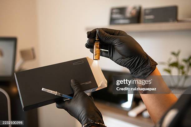 female dermatologist preparing mesotherapy injections for her patient. - mesotherapy stock pictures, royalty-free photos & images