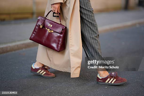 Patricia Wirschke is seen wearing a classic beige long Herno trench coat; a pair of high-waisted, wide-leg, ankle length Rossi pants that feature a...