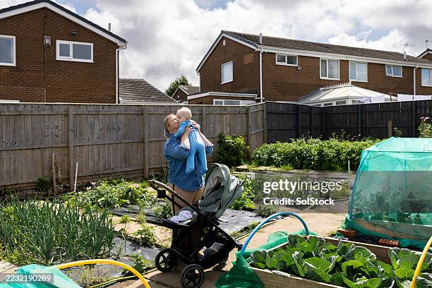 Mother Holding Baby At Family Allotment High-Res Stock Photo