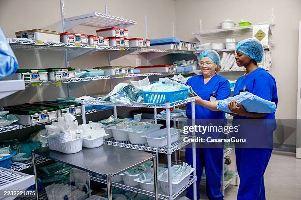 enfermera recogiendo suministros médicos para una próxima cirugía en un almacén del hospital - material médico fotografías e imágenes de stock