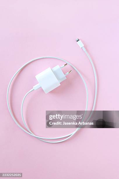 white usb wall charger and cable on pink background - chargeur de batterie photos et images de collection