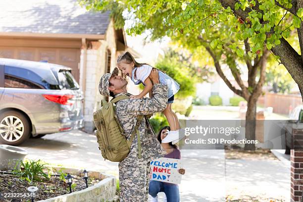 soldier's heartwarming homecoming: family reunion with child - welcome home stock pictures, royalty-free photos & images