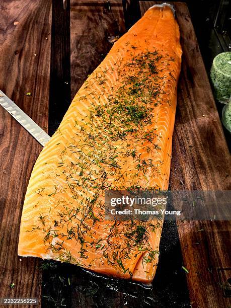 gravlax salmon fillet with fresh dill on wooden board - graved lachs stock-fotos und bilder
