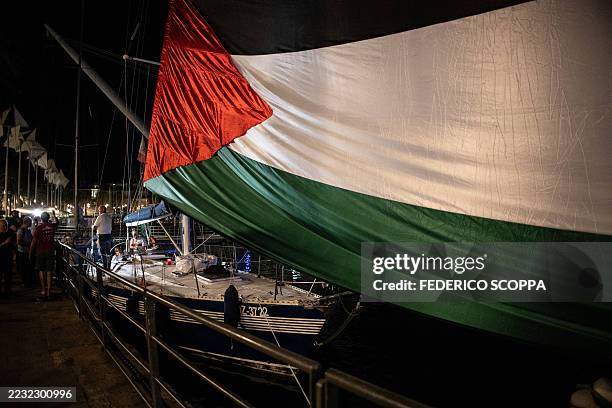 Giant Palestinian flag is deployed where four boats will leave to Gaza joining the "Global Sumud Flotilla" gather in Genoa harbor on August 30, 2025....