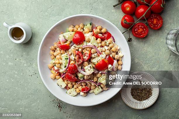 delicious salad with chickpeas, tomato, cucumber, feta cheese, onion and fresh herbs - salad bowl stock pictures, royalty-free photos & images