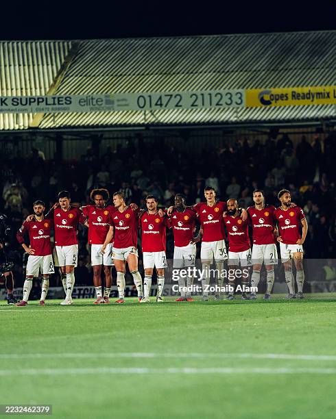 The Manchester United team watch the penalty shoot out during the Carabao Cup Second Round match between Grimsby Town and Manchester United at...