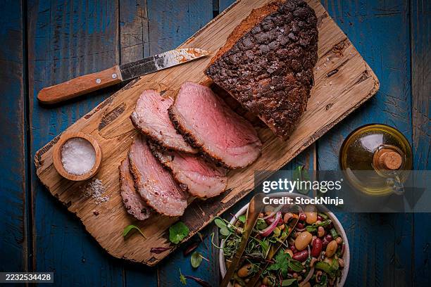 delizioso roast beef a fette con insalata servito su piatto di legno - arrosto di manzo foto e immagini stock