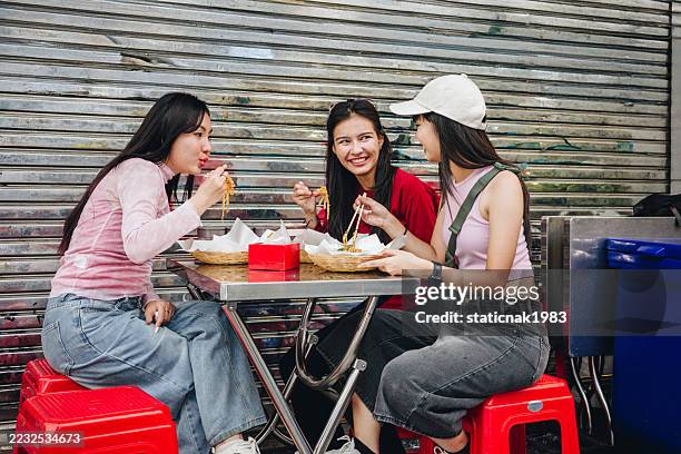 asian couple women having the date on street food. - thai food stock pictures, royalty-free photos & images