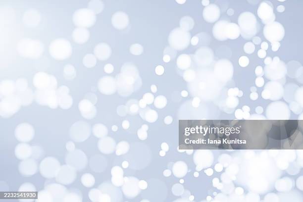 soft blue, silver and white snow abstract bokeh background with blurred light circles and glowing highlights. minimal dreamy texture, perfect for winter, christmas, holiday, celebration, or clean modern design concepts. - white flare stock pictures, royalty-free photos & images