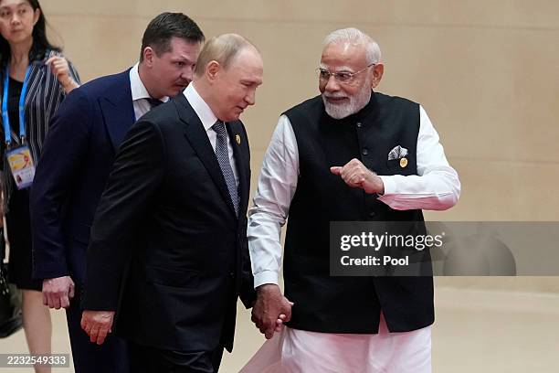 Indian Prime Minister Narendra Modi walks next to Russian President Vladimir Putin during the Shanghai Cooperation Organization Summit 2025 at the...