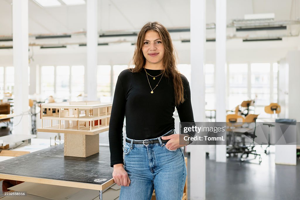 Porträt einer jungen Architekturstudentin, die im Arbeitsbereich eines Designstudios steht