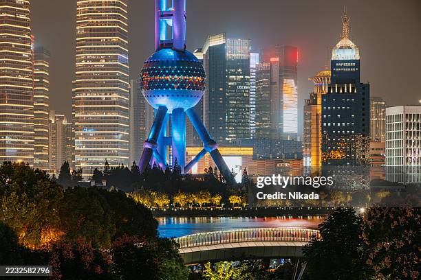 horizonte moderno de shanghái iluminado por la noche con reflejos - vista de la tierra fotografías e imágenes de stock
