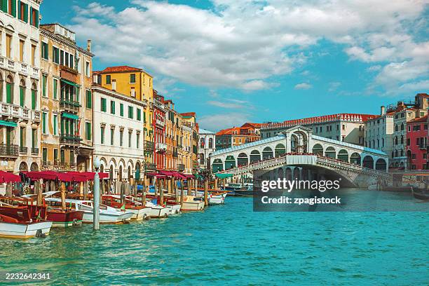 rialto bridge over grand canal with colorful venetian palaces, italian heritage, architectural masterpiece, venice tourism - uitzicht over stadje stockfoto's en -beelden