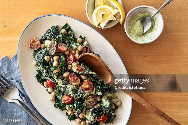 chickpea kale salad with cherry tomatoes and herb yogurt dressing - couve imagens e fotografias de stock