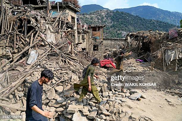 Graphic content / Afghans walk past damaged houses, after earthquakes at Mazar Dara village in Nurgal district, Kunar province, in Eastern...