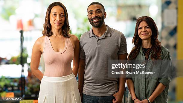 three diverse adults posing together in a retail or greenhouse environment — group portrait with soft window light - medium shot stock pictures, royalty-free photos & images