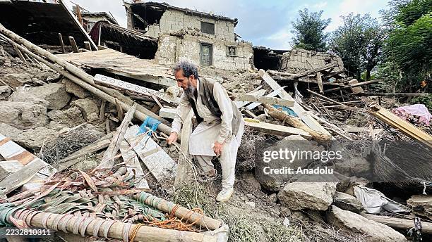People are seen outside near severely damaged houses after a 6.0-magnitude earthquake struck Afghanistan's eastern Kunar province on September 02,...