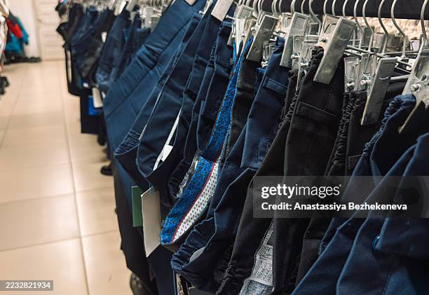 school uniform trousers on hangers in a store - polyester stock pictures, royalty-free photos & images