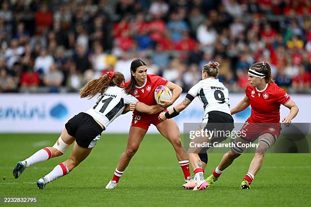 Julia Schell of Canada is tackled by Lisa Neumann and Keira Bevan of Wales during the Women's Rugby World Cup 2025 Pool B match between Canada and...