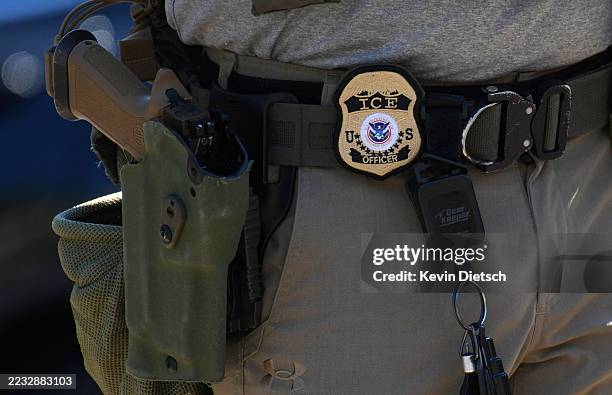 An Immigration and Customs Enforcement officer's badge and weapon are seen as ICE conducts a vehicle checkpoint on Georgia Ave. On August 30, 2025 in...