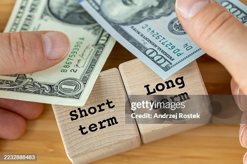 Long-term and short-term profits. Business concept. Long-term strategy yields more profit. One-dollar bill as short-term profit and 100 dollars as a symbol of prospective growth Long-term and short-term profits. Business concept. Long-term strategy yields more profit. One-dollar bill as short-term profit and 100 dollars as a symbol of prospective growth
