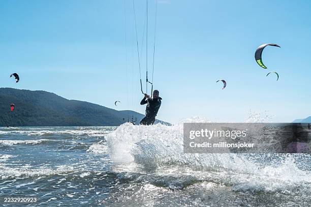 kitesurfer führt sprungtrick über dem wasser vor, türkei - luftsport stock-fotos und bilder