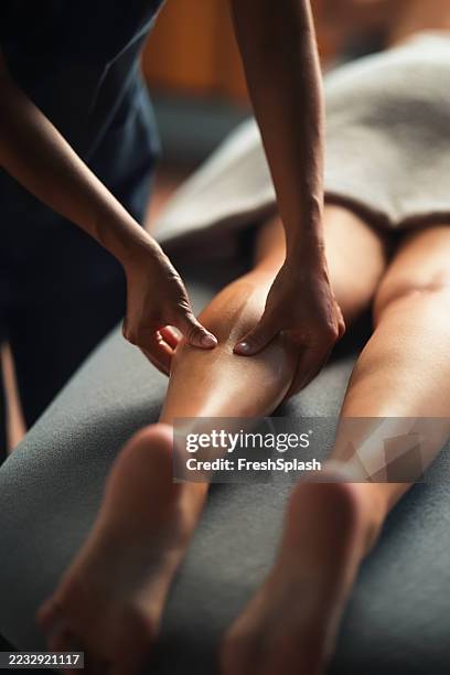 relaxation therapy featuring leg massage on a comfortable spa bed - human leg stock pictures, royalty-free photos & images